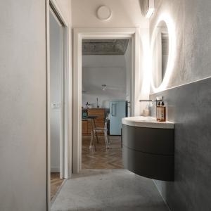 a bathroom with a sink and a room with a table at La Camera Verde in Pisa