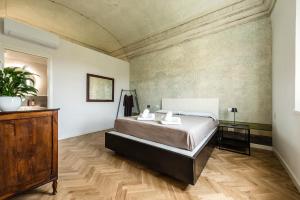 a bedroom with a bed and a wooden floor at La Camera Verde in Pisa