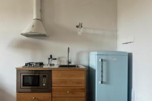 a kitchen with a blue refrigerator and a sink at La Camera Verde in Pisa +12 photos