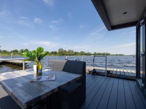 a dining table on the deck of a boat at Tiny houseboat Parel I - airco in Uitgeest