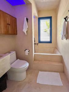 La salle de bains est pourvue de toilettes, d'une baignoire et d'un lavabo. dans l'établissement Casa Omero., à El Cuyo