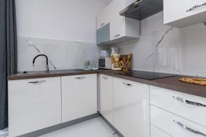 Biała kuchnia z białymi szafkami i zlewem w obiekcie Apartments by the sea Klenovica, Novi Vinodolski - 5557 w mieście Klenovica +29 zdjęć