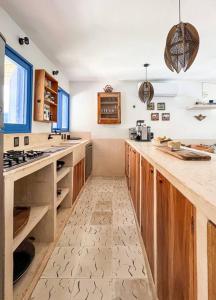 une grande cuisine avec des placards en bois et un comptoir. dans l'établissement Casa Omero., à El Cuyo
