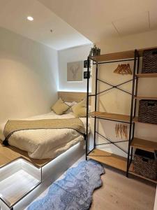 1 dormitorio con cama y estante para libros en 2Brooms Max for5 at Heart of CBD 1Free Parking, en Melbourne