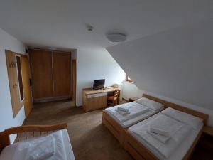 a bedroom with a bed and a desk with a computer at Horský hotel Hájenka in Makov