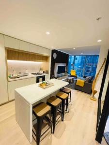 een keuken met een tafel en stoelen en een woonkamer bij 2Brooms Max for5 at Heart of CBD 1Free Parking in Melbourne
