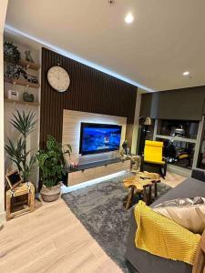 een woonkamer met een flatscreen-tv aan de muur bij 2Brooms Max for5 at Heart of CBD 1Free Parking in Melbourne