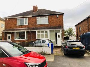 two cars parked in front of a brick house at Holiday inn house in Longton