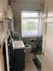 łazienka z umywalką, toaletą i oknem w obiekcie Holiday inn house w mieście Longton