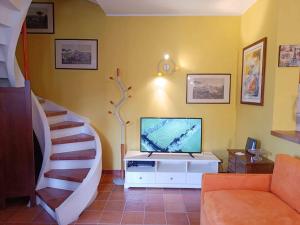 un salon avec un escalier et une télévision dans l'établissement [Oltrepo'] Dimora nei vigneti vicino a Ics Maugeri, à Santa Maria della Versa