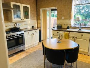 Holiday inn house في Longton: مطبخ مع طاولة خشبية وموقد