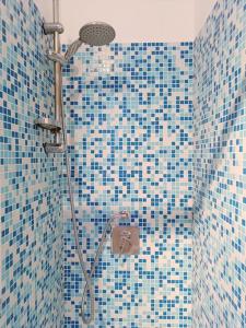 baño con ducha con azulejos azules en la pared en [Oltrepo'] Dimora nei vigneti vicino a Ics Maugeri, en Santa Maria della Versa