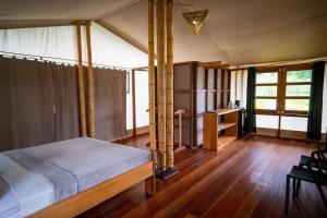 een slaapkamer met een bed en een bureau in een kamer bij Houttuyn Wellness River Resort in Paramaribo