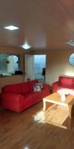salon z czerwoną kanapą i stołem w obiekcie Casa do Mirante w mieście Petrópolis