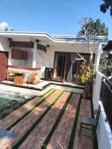 a backyard with a wooden deck and a house at Baruna Sari Villa view jungle in Ubud