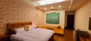 a bedroom with a bed and a sign that says love at On One Side Homestay in Lugu Lake