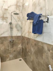 a bathroom with a shower with blue towels at Baruna Sari Villa yoga and reatret view jungle in Ubud