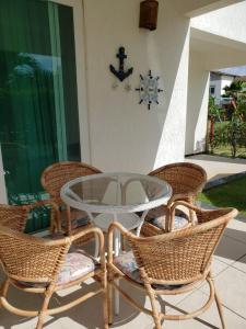 a glass table and wicker chairs on a patio at Apartamento Particular de 03 suítes, Resort Treebies, Praia de Subauma - Ba in Entre Rios
