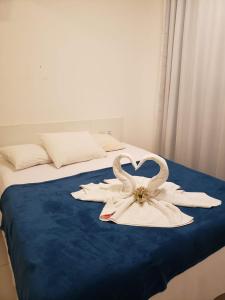 una cama con dos cisnes hechos de toallas en Apartamento Particular de 03 suítes, Resort Treebies, Praia de Subauma - Ba, en Entre Rios