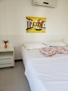 um quarto com duas camas e um quadro na parede em Apartamento Particular de 03 suítes, Resort Treebies, Praia de Subauma - Ba em Entre Rios