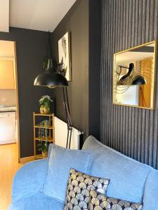 a living room with a blue couch and a mirror at Especial Familias Golden - Soldeu - Parking Gratis in Soldeu