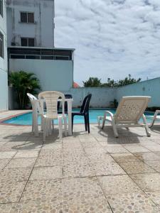 um pátio com cadeiras e uma mesa ao lado de uma piscina em Departamento Tonsupa 