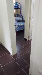 um corredor com um quarto com uma cama e um piso de azulejo em Departamento Tonsupa 
