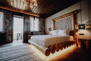 a bedroom with a large bed and a large window at KERCULLA Resort in Gjirokastër