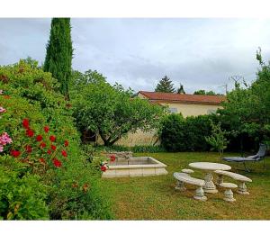 einen Garten mit drei Picknicktischen und einem Brunnen in der Unterkunft Chambre et sdb privée in Valréas