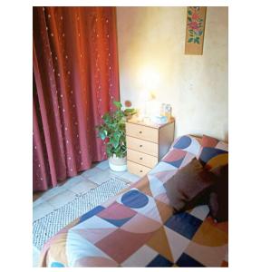 ein Schlafzimmer mit einem Bett und eine Kommode mit einer Pflanze in der Unterkunft Chambre et sdb privée in Valréas