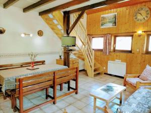 een woonkamer met een tafel en een klok aan de muur bij Gîte La Bresse, 3 pièces, 4 personnes - FR-1-589-97 in La Bresse