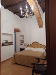 een slaapkamer met een bed en een kroonluchter bij Charming apartment in medieval tower in Spoleto