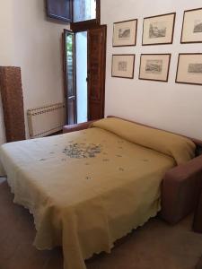 een slaapkamer met een bed met een deken erop bij Charming apartment in medieval tower in Spoleto