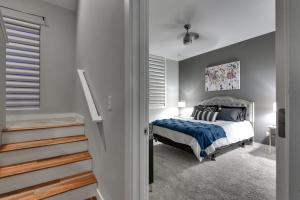 a bedroom with a bed with a blue comforter at Modern Townhome Near Downtown with Amazing Views in Omaha
