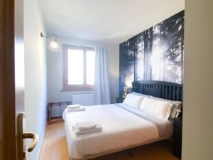 a bedroom with a large bed with white sheets at Especial Familias Golden - Soldeu - Parking Gratis in Soldeu