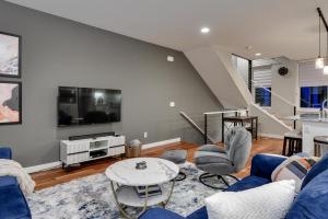 uma sala de estar com um sofá azul e uma mesa em Modern Townhome Near Downtown with Amazing Views em Omaha