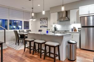 a kitchen with a large island with bar stools at Modern Townhome Near Downtown with Amazing Views in Omaha