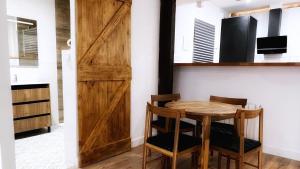 a room with a wooden door and a table and chairs at Bilbao Ronda apartamento con balcón Casco Viejo in Bilbao