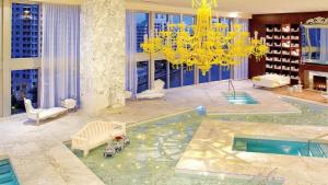ein Wohnzimmer mit einem Kronleuchter und einem Pool in der Unterkunft Highest floor Icon W Brickell Location in Miami