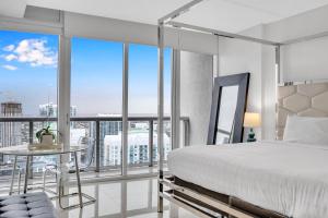 a bedroom with a bed and a view of a city at Highest floor Icon W Brickell Location in Miami +24 photos
