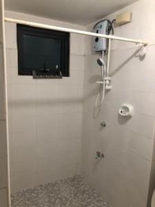 a bathroom with a shower with a television on the wall at ADB Avenue Tower Ortigas Manila in Manila