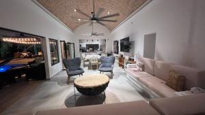 een woonkamer met een bank, stoelen en een tafel bij Casa Privada en Exclusivo Club Privado in Ricaurte