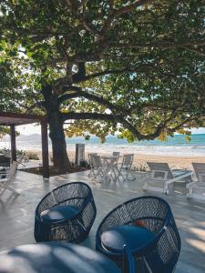 a group of chairs and tables on the beach at Pousada Vô Jaques in Porto Belo