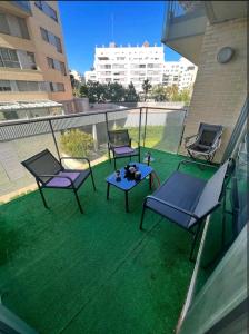 einen Balkon mit 3 Stühlen und einem Tisch auf dem Rasen in der Unterkunft apartment in Valencia