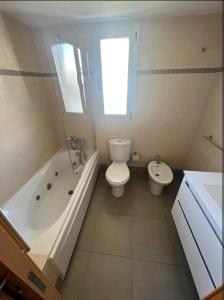 a bathroom with a toilet and a tub and a sink at apartment in Valencia