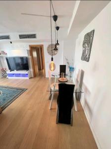 sala de estar con mesa, sillas y TV en apartment en Valencia