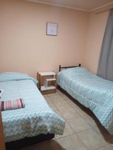 1 dormitorio con 2 camas y mesita de noche entre ellas en Cabaña La Guanaca en Comandante Luis Piedra Buena