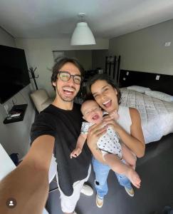 a man and a woman holding a baby in a bedroom at Living Hotel São Paulo in São Paulo