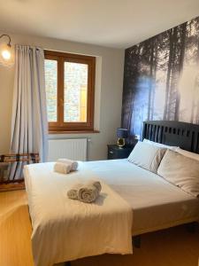 - une chambre avec un lit et des serviettes dans l'établissement Especial Familias Golden - Soldeu - Parking Gratis, à Soldeu