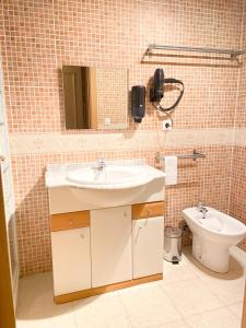 La salle de bains est pourvue d'un lavabo et de toilettes. dans l'établissement Especial Familias Golden - Soldeu - Parking Gratis, à Soldeu